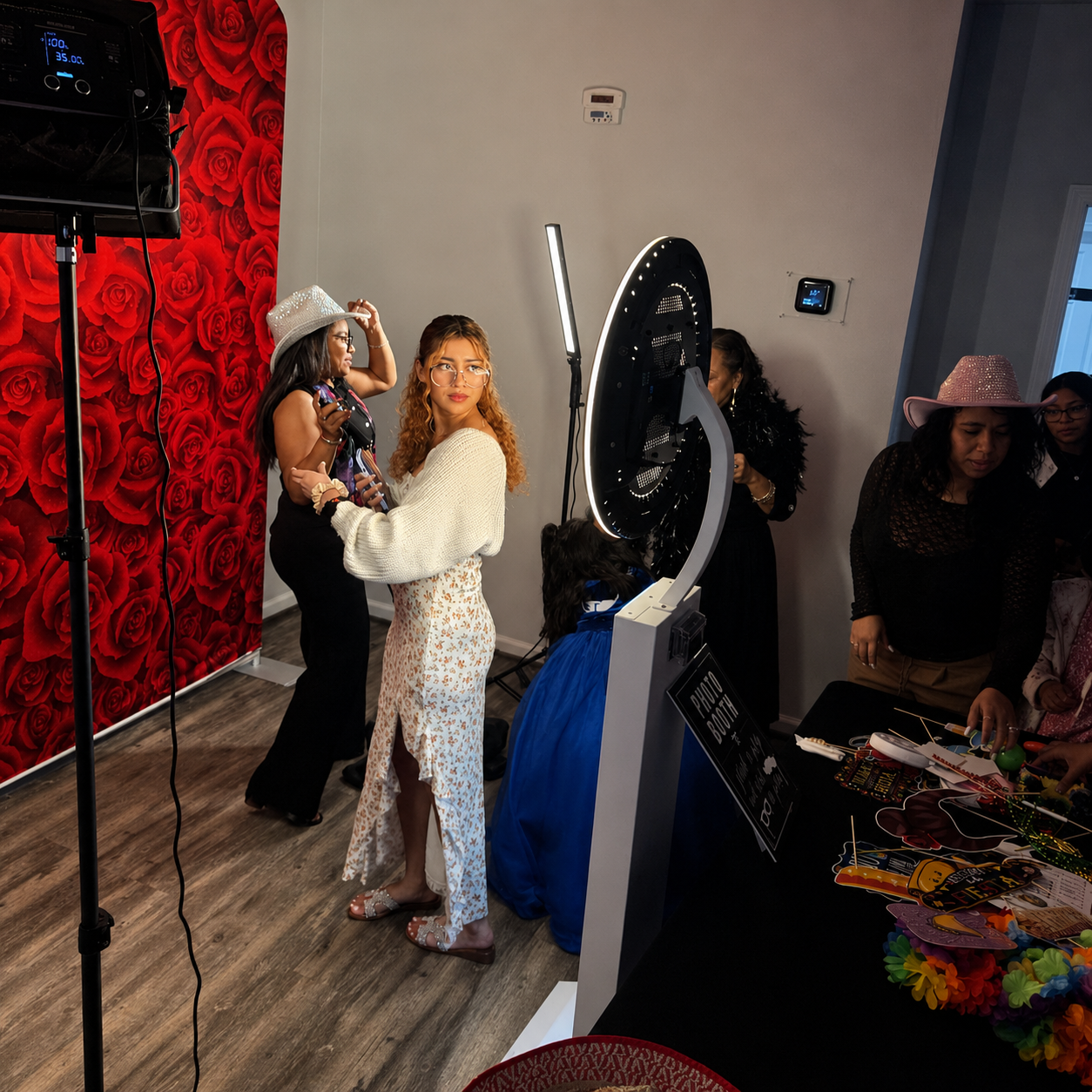 Luminary mirror photo booth set against a red rose backdrop